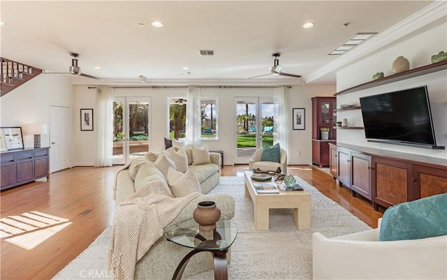 living room featuring light wood-style flooring, recessed lighting, a ceiling fan, visible vents, and stairway