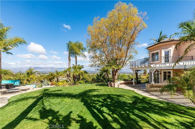 view of yard featuring a balcony and a patio