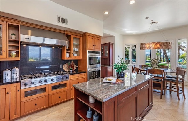 kitchen with visible vents, brown cabinetry, wall chimney exhaust hood, stainless steel appliances, and open shelves