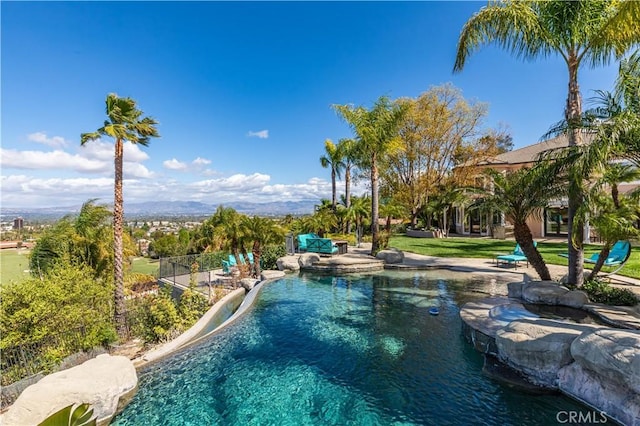 outdoor pool with a yard, a patio, and fence