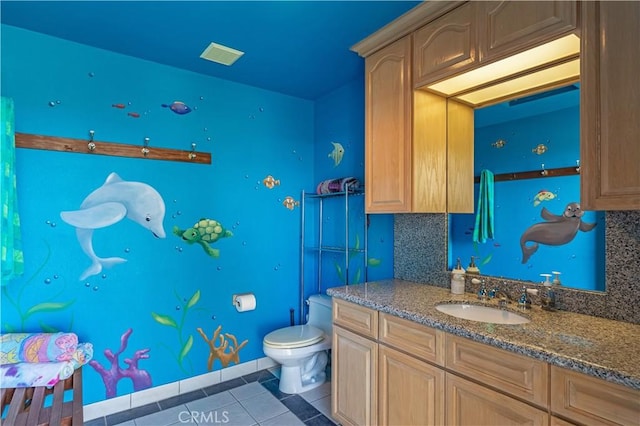 bathroom featuring vanity, tile patterned flooring, and toilet