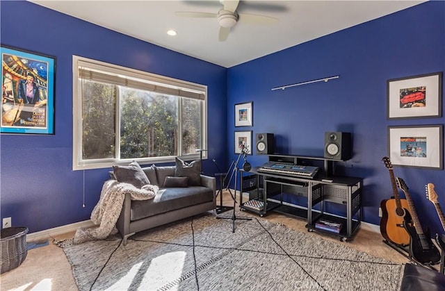 living area featuring ceiling fan and baseboards