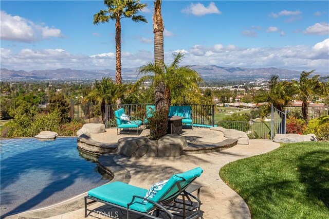 exterior space with a mountain view, fence, and a patio