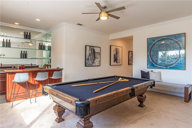 recreation room with crown molding, a ceiling fan, indoor wet bar, and light colored carpet