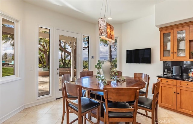 dining space featuring baseboards and light tile patterned flooring