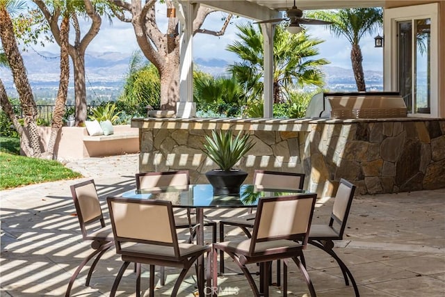 view of patio with ceiling fan, area for grilling, and outdoor dining space