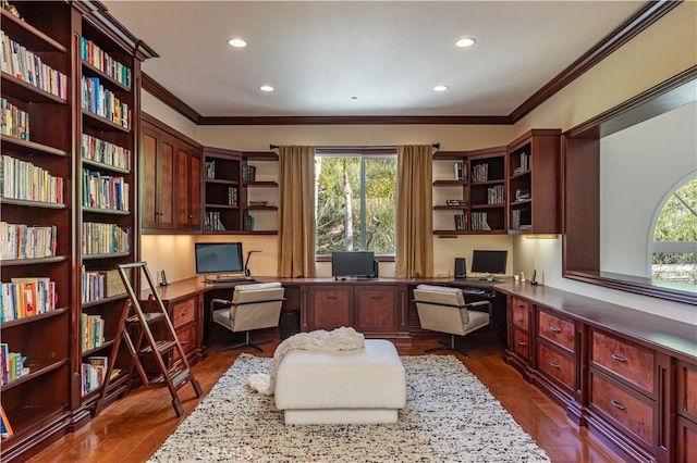 office with ornamental molding, dark wood finished floors, plenty of natural light, and built in desk