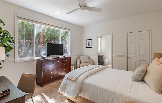 bedroom featuring ensuite bath, a ceiling fan, and light colored carpet