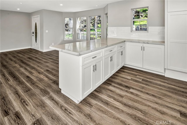 kitchen with dark wood finished floors, recessed lighting, decorative backsplash, white cabinetry, and a peninsula