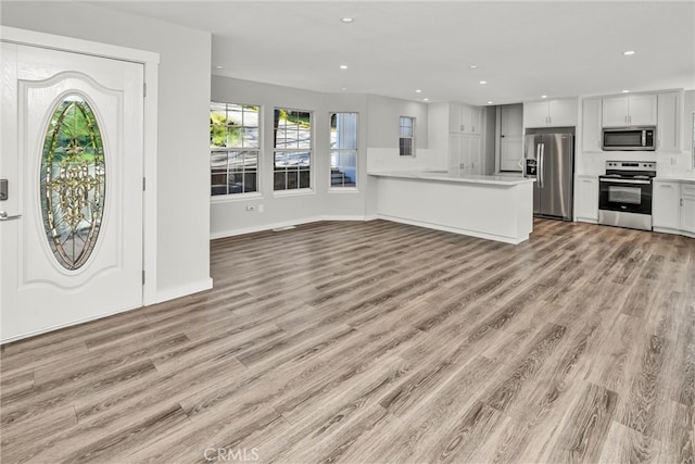 foyer featuring recessed lighting, baseboards, and light wood finished floors