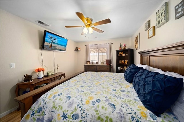 bedroom with visible vents, ceiling fan, baseboards, and wood finished floors