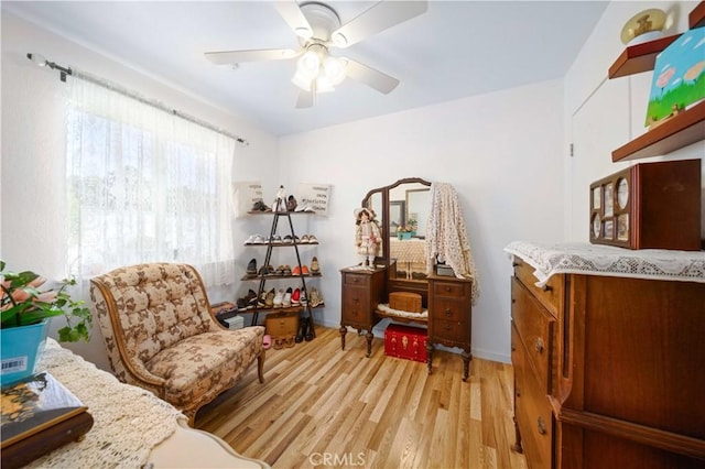 living area with light wood-type flooring and ceiling fan