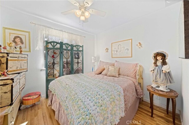 bedroom with baseboards, light wood-style flooring, and a ceiling fan