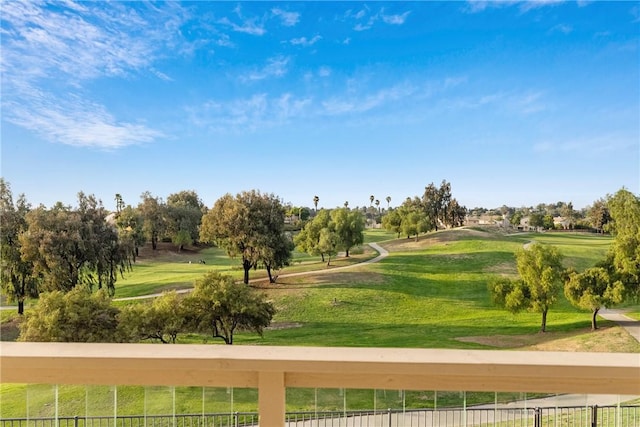 surrounding community with golf course view and a yard