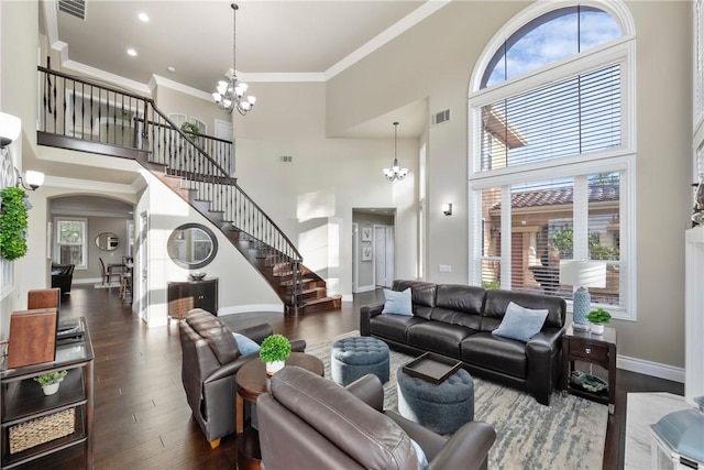 living area with visible vents, ornamental molding, wood finished floors, stairway, and a chandelier