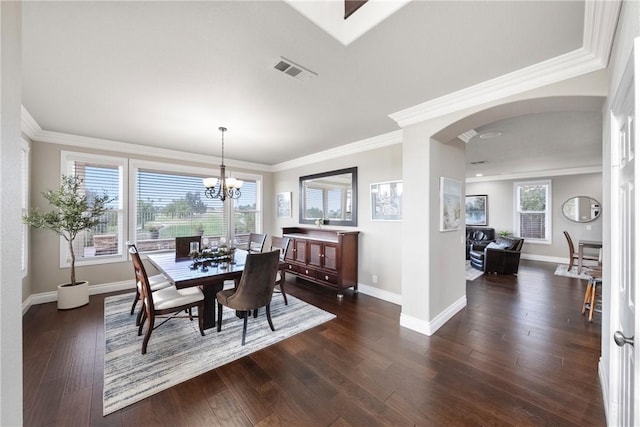 dining area with arched walkways, visible vents, baseboards, and dark wood-style flooring