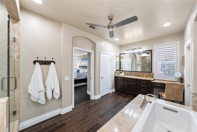 ensuite bathroom with visible vents, wood tiled floor, a stall shower, ensuite bathroom, and vanity