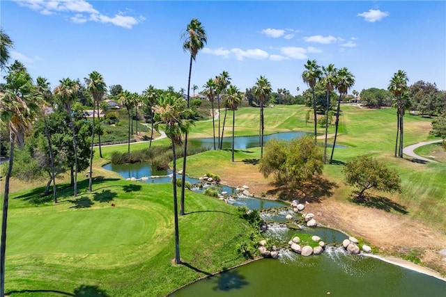 view of property's community with view of golf course and a yard