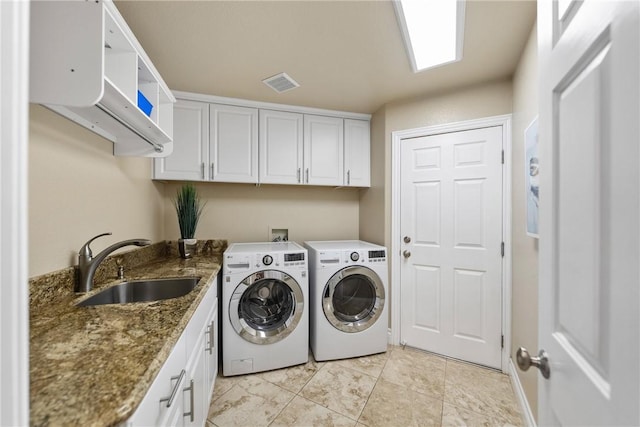 laundry area with washing machine and clothes dryer, visible vents, cabinet space, and a sink