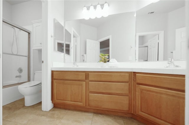 full bath featuring shower / bath combination with glass door, double vanity, a sink, tile patterned floors, and toilet