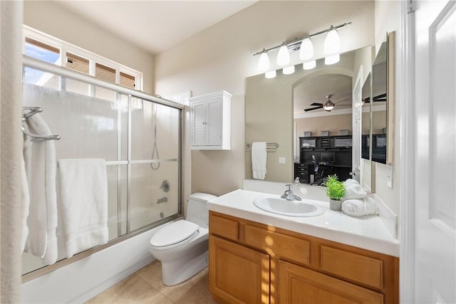 full bath featuring tile patterned floors, toilet, shower / bath combination with glass door, ceiling fan, and vanity