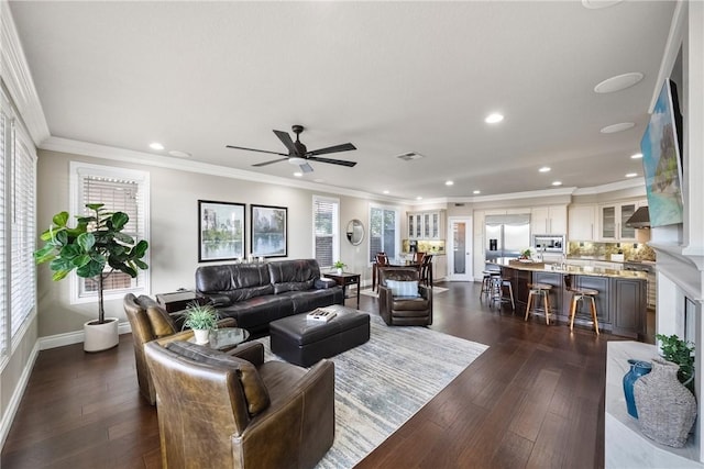 living area with visible vents, crown molding, baseboards, recessed lighting, and dark wood-style floors