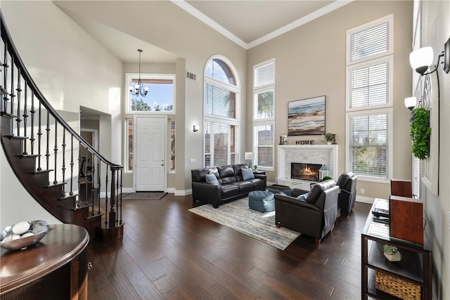 living room with visible vents, baseboards, dark wood-style flooring, stairs, and crown molding