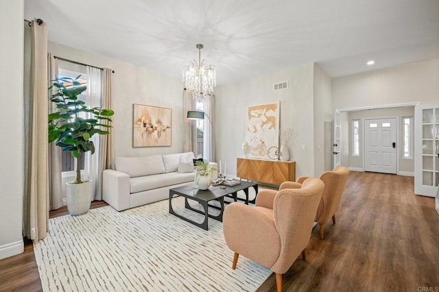 living area with visible vents, plenty of natural light, and wood finished floors