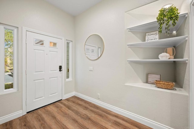 foyer featuring wood finished floors and baseboards