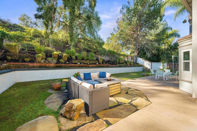 view of patio with outdoor dining space, fence, and a fire pit