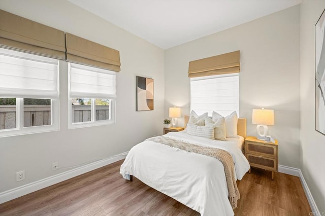 bedroom with wood finished floors and baseboards