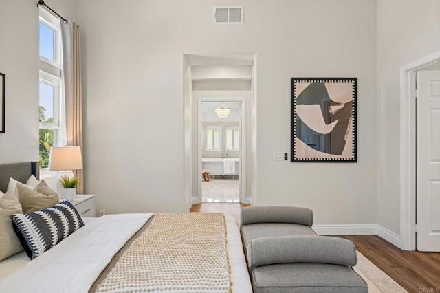 bedroom featuring baseboards, visible vents, and wood finished floors