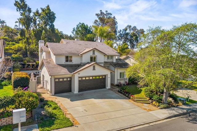 traditional home featuring a tile roof, a chimney, stucco siding, a garage, and driveway