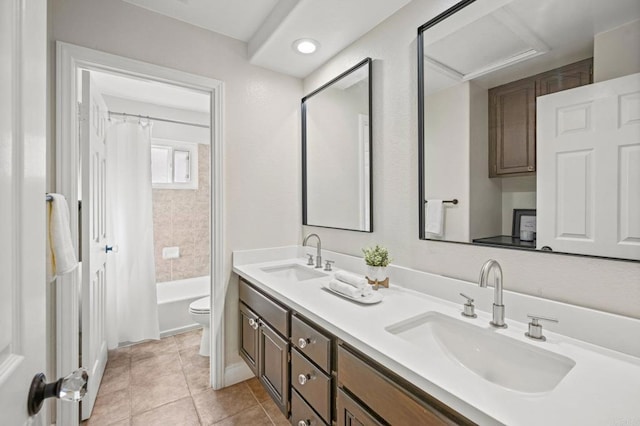 bathroom featuring tile patterned flooring, a sink, toilet, and double vanity