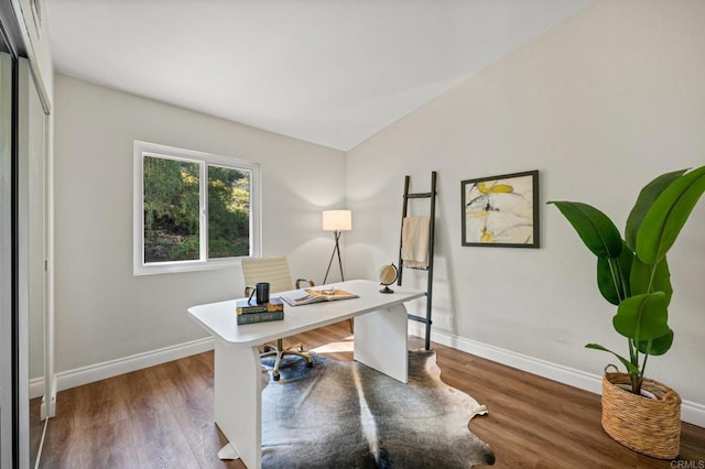 office space with lofted ceiling, wood finished floors, and baseboards