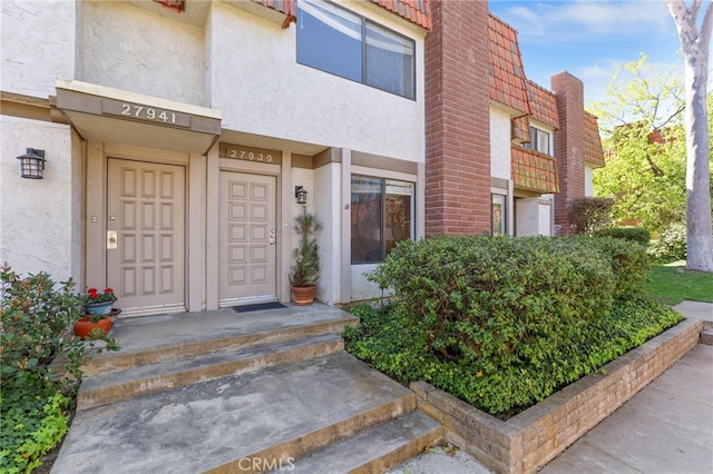 property entrance with stucco siding