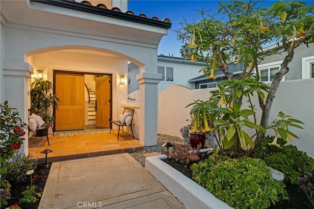 entrance to property with fence and stucco siding