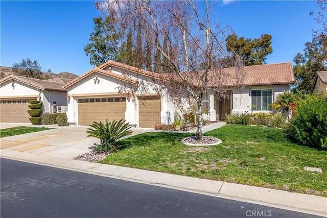 view of front of property with concrete driveway, a tiled roof, an attached garage, a front lawn, and stucco siding