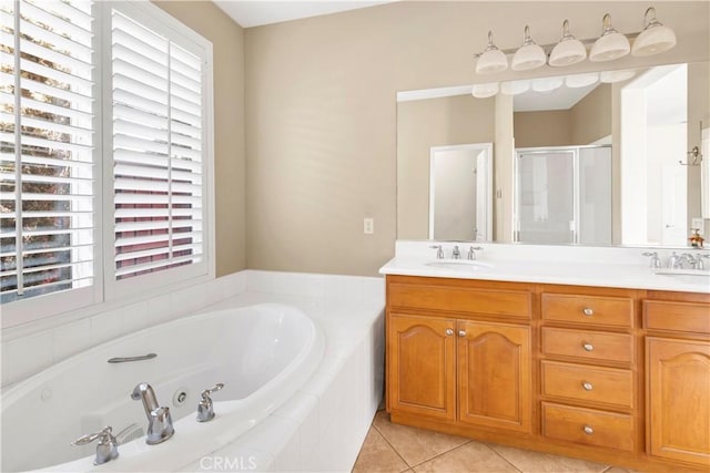 bathroom with a jetted tub, a shower stall, double vanity, and a sink