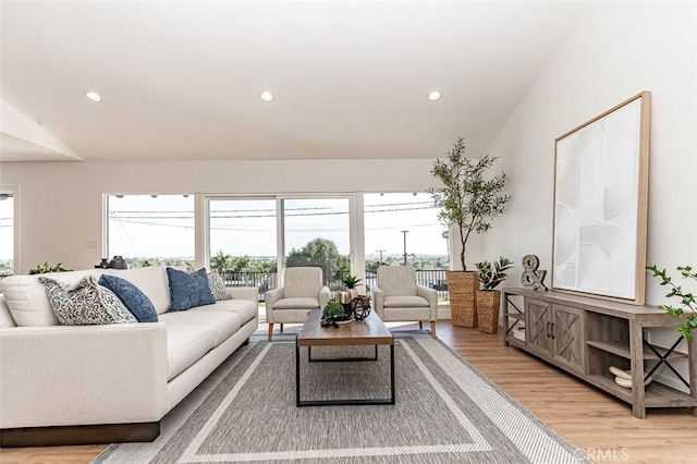 living room featuring lofted ceiling, light wood finished floors, and recessed lighting