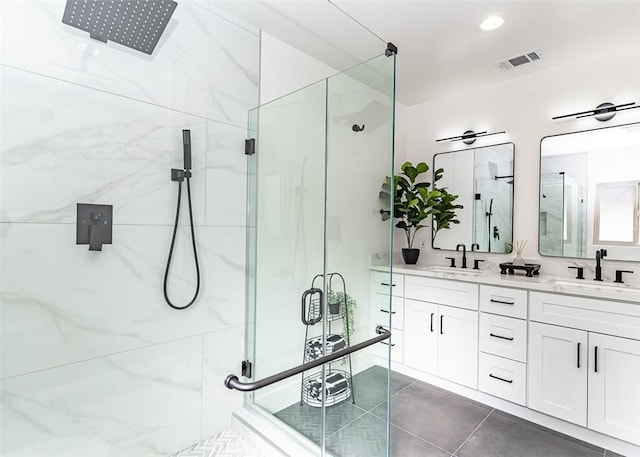 full bathroom with visible vents, double vanity, a sink, and a marble finish shower