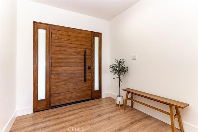 foyer entrance featuring light wood-style floors and baseboards