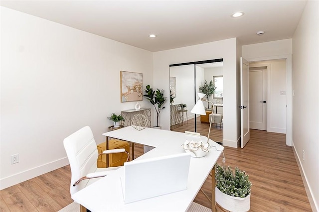 home office featuring light wood-type flooring, baseboards, and recessed lighting