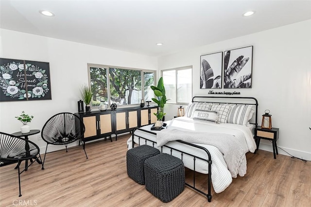 bedroom featuring baseboards, wood finished floors, and recessed lighting