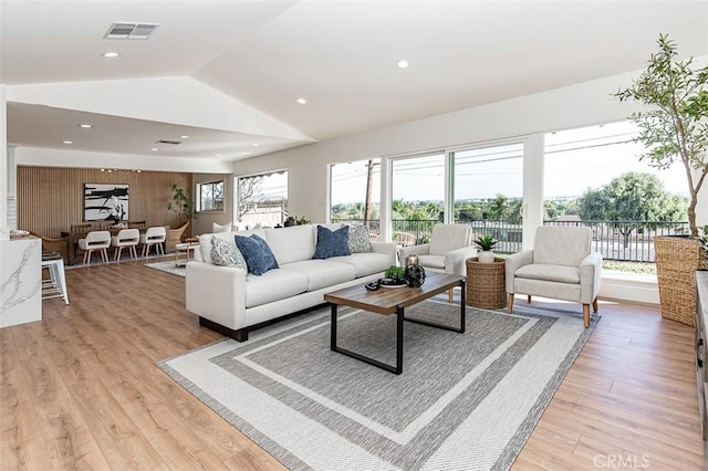 living room with lofted ceiling, light wood finished floors, visible vents, and recessed lighting