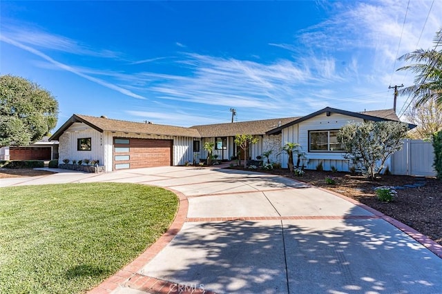 view of front facade with driveway, a front lawn, an attached garage, and fence