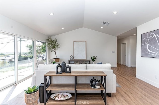 living area featuring light wood finished floors, baseboards, visible vents, lofted ceiling, and recessed lighting