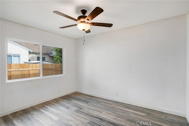 spare room featuring baseboards, ceiling fan, and wood finished floors