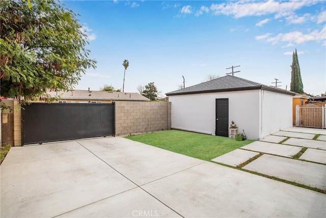 exterior space with driveway, fence, a gate, and a garage