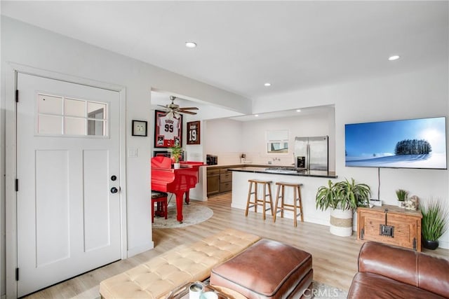 living area with recessed lighting, a ceiling fan, and light wood-type flooring